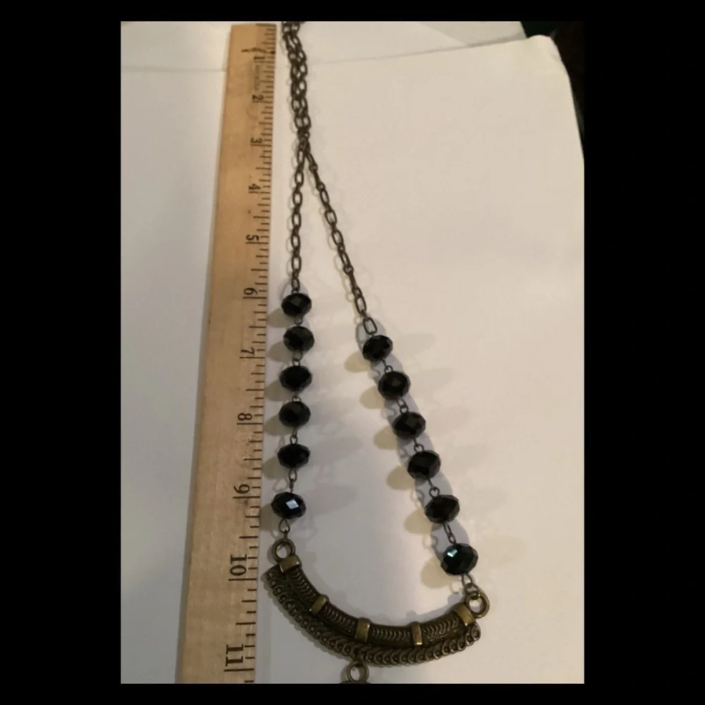 Black and cream vintage necklace on a bronze chain.